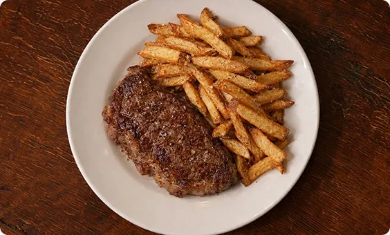 Steak frites on a white plate