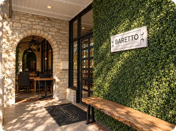 Baretto's entrance with its stone archway, sign, and green wall